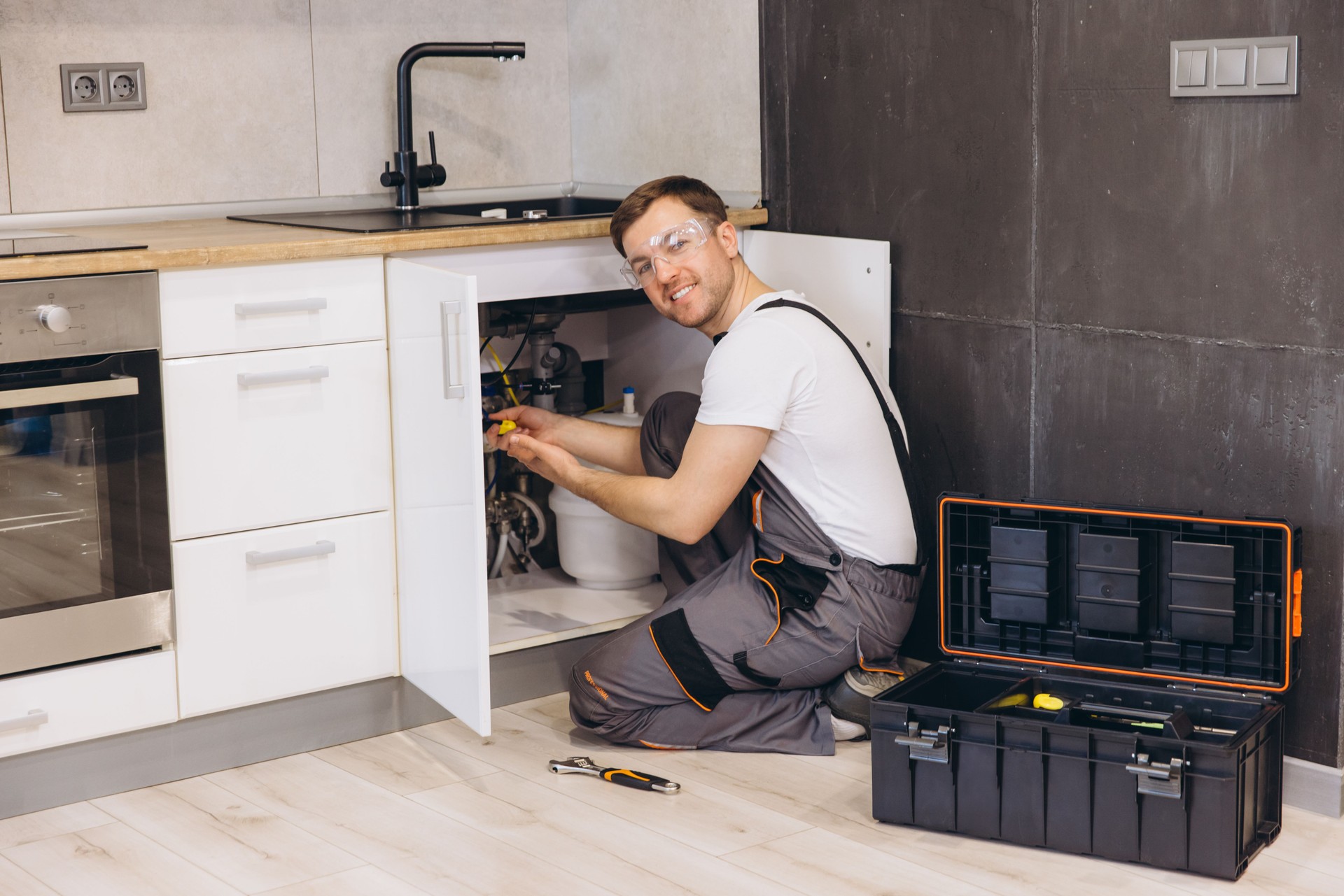 Plumber Installing Water Filter System Under Kitchen Sink